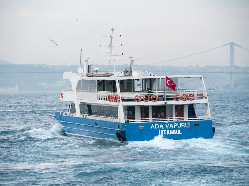 Ferry sailing on the Bosphorus with the bridge in the distance